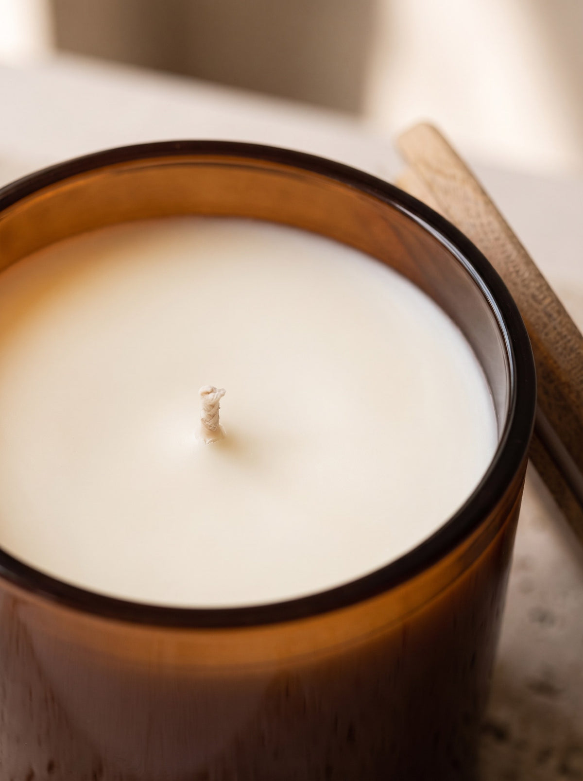 Close-up of the cream soy wax surface and cotton wick of the Amber & Fig candle