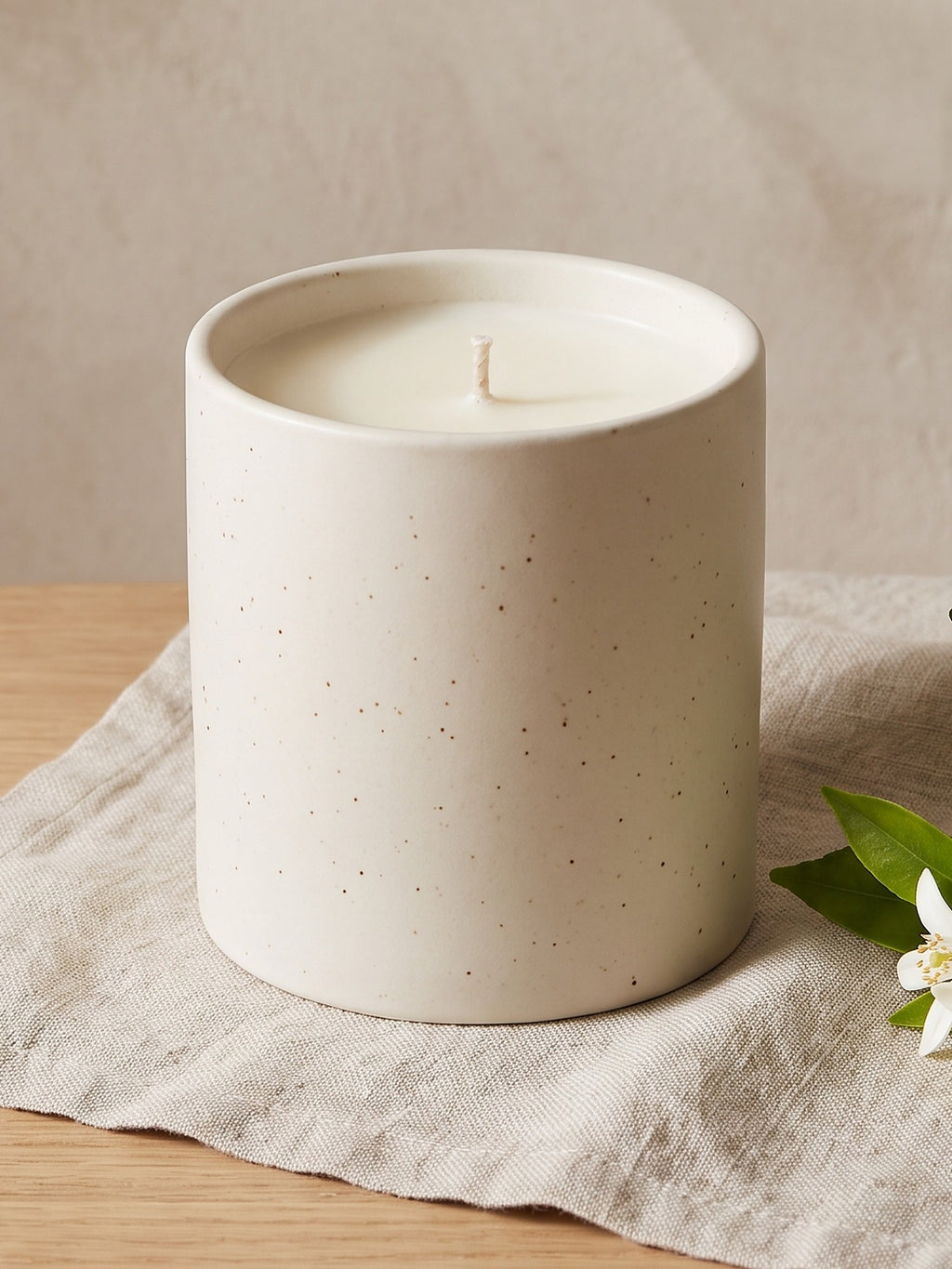Close-up of the cream soy wax and cotton wick inside the speckled Linen & Neroli stoneware pot