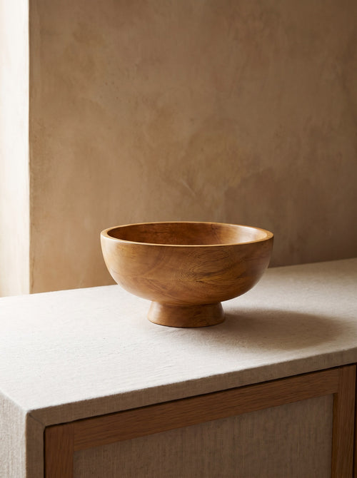 Mango Wood Pedestal Bowl with warm natural grain on a linen-covered sideboard
