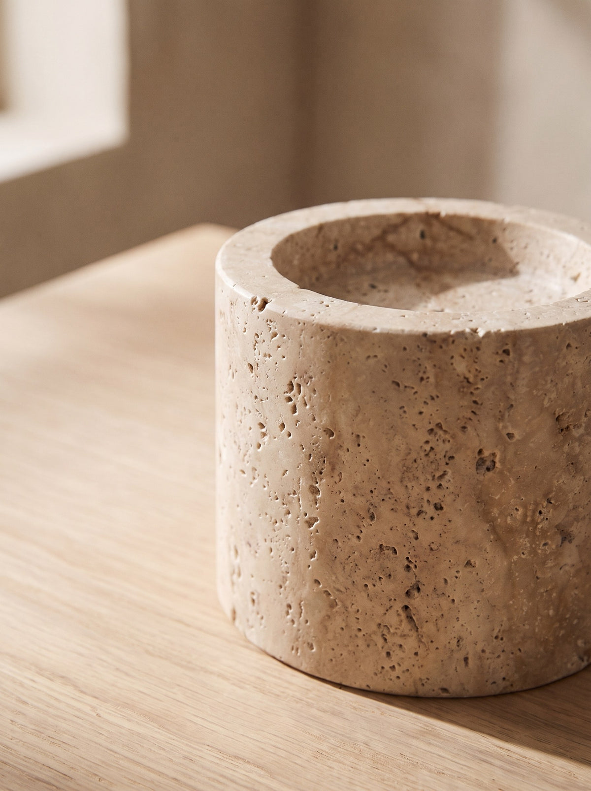 Close-up of the natural pitted texture of the honed travertine candle holder